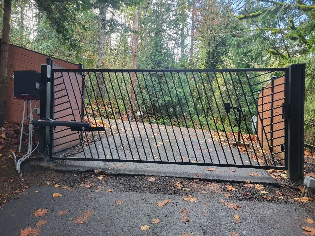 Automated wood and steel entry gate on a wooded Western Washington driveway