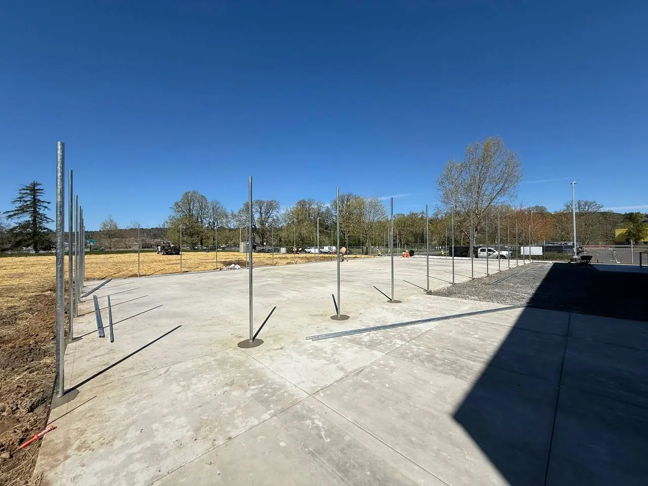 Steel fence posts set in concrete on an active jobsite